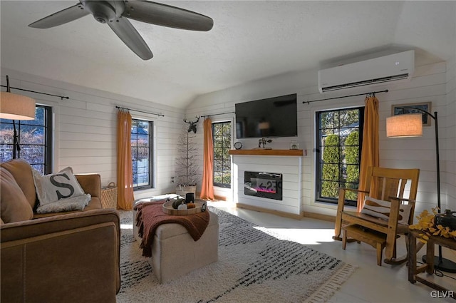 living room featuring ceiling fan, vaulted ceiling, a wealth of natural light, and a wall unit AC