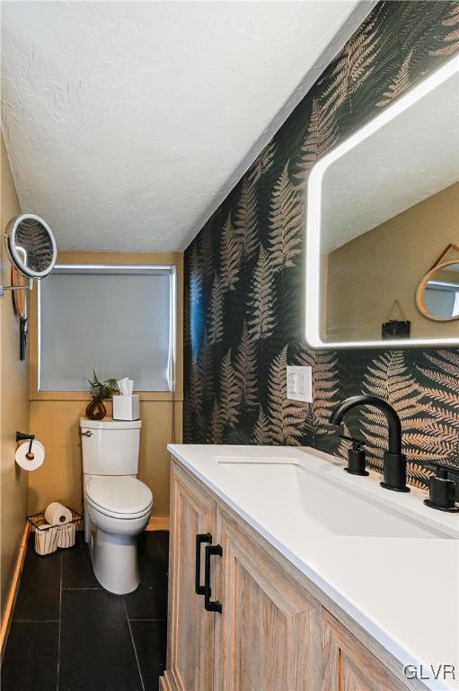 bathroom featuring toilet, vanity, and tile patterned flooring