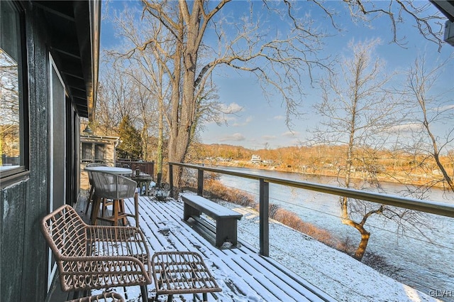 snow covered deck featuring a water view