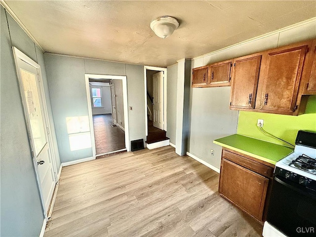 kitchen featuring white gas range and light hardwood / wood-style floors