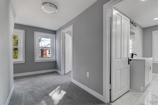 hall featuring light carpet and sink