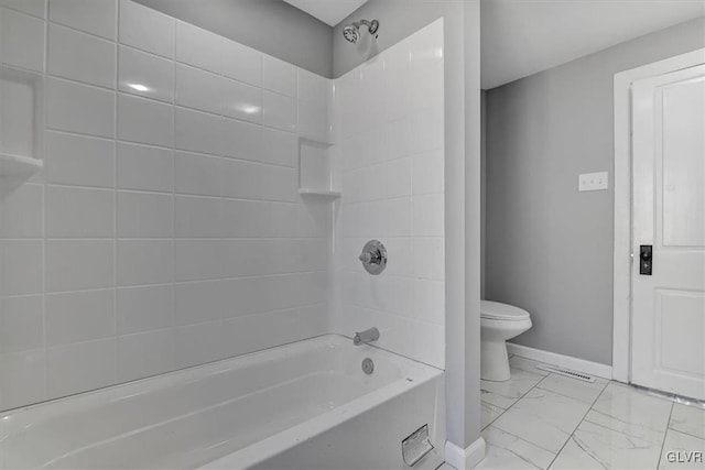 bathroom featuring tiled shower / bath combo and toilet