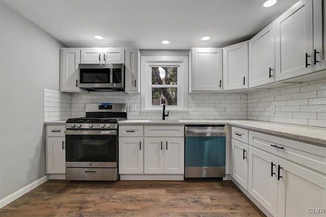 kitchen with white cabinetry, appliances with stainless steel finishes, sink, and dark hardwood / wood-style floors