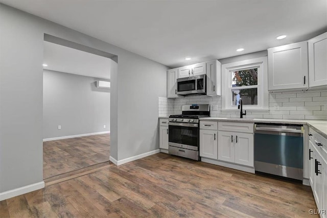 kitchen with white cabinets, stainless steel appliances, and dark hardwood / wood-style flooring