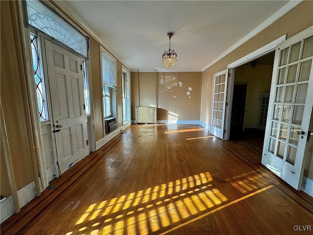 interior space with ornamental molding, radiator, dark hardwood / wood-style floors, and an inviting chandelier