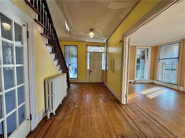 entrance foyer featuring radiator heating unit and hardwood / wood-style flooring