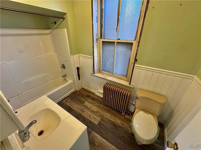 bathroom with toilet, radiator, shower / bathing tub combination, and hardwood / wood-style flooring