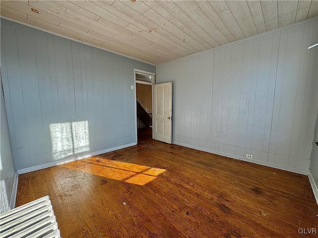 spare room with wood walls, hardwood / wood-style flooring, and wood ceiling