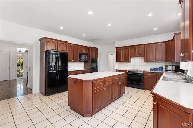 kitchen featuring tasteful backsplash, black appliances, sink, and a kitchen island