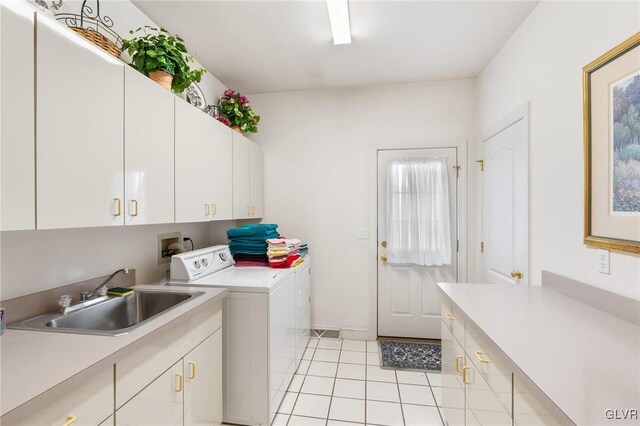 laundry room with cabinets, light tile patterned flooring, sink, and washer and dryer