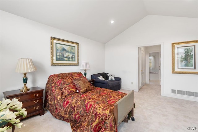 bedroom featuring lofted ceiling, light colored carpet, and ensuite bath