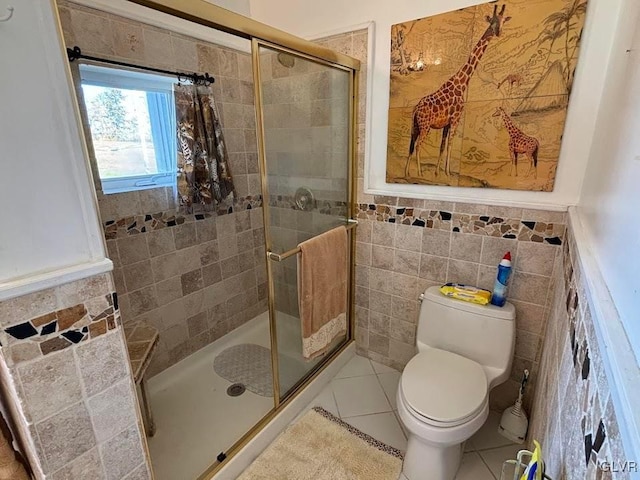 bathroom featuring tile walls, tile patterned flooring, an enclosed shower, and toilet