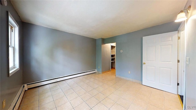 tiled spare room with a baseboard radiator