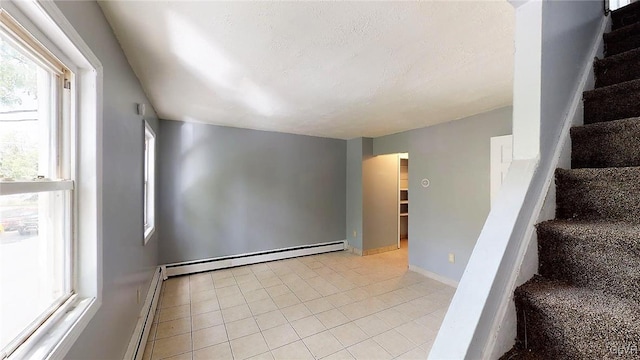 unfurnished room featuring light tile patterned floors and a baseboard radiator