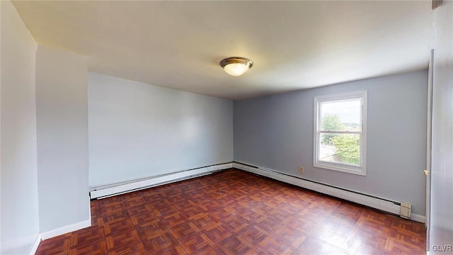 spare room with dark parquet flooring and a baseboard heating unit