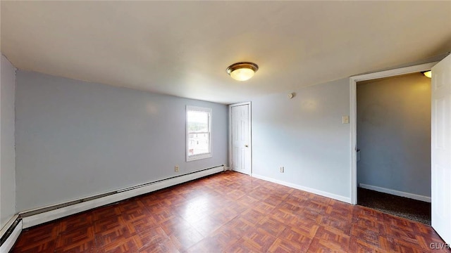 empty room featuring baseboard heating and parquet floors