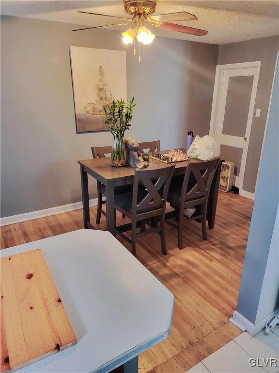 dining room featuring a textured ceiling, hardwood / wood-style flooring, and ceiling fan