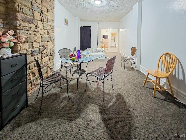 carpeted dining area with a textured ceiling