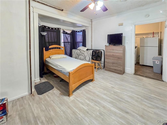 bedroom with light hardwood / wood-style floors, a textured ceiling, ornamental molding, ceiling fan, and white fridge