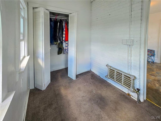 unfurnished bedroom featuring dark colored carpet and a closet