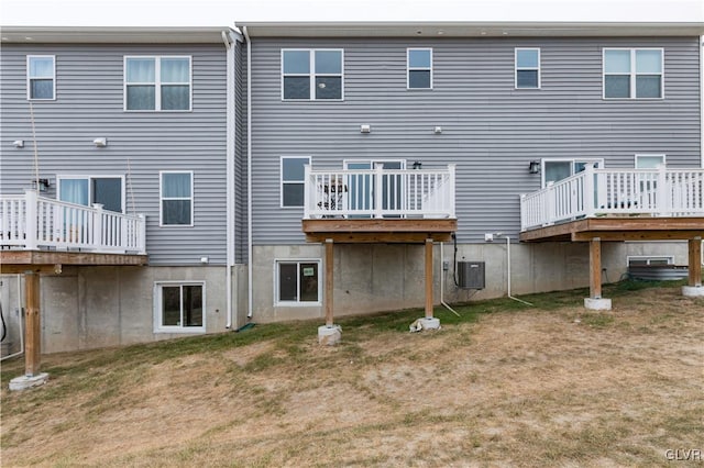 rear view of property featuring a wooden deck and a yard