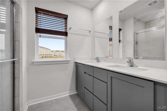 bathroom featuring tile patterned flooring, vanity, and a shower with door