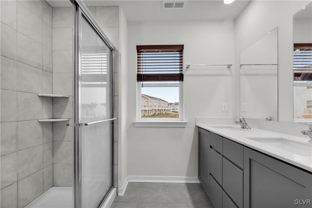 bathroom with tile patterned floors, vanity, and an enclosed shower