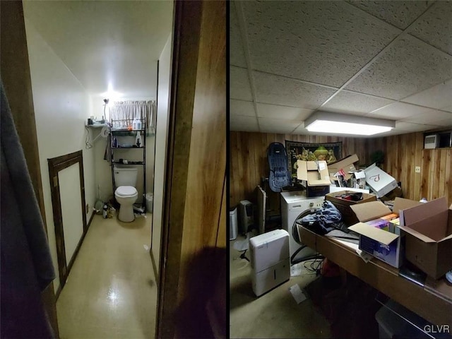 interior space featuring a paneled ceiling and wood walls