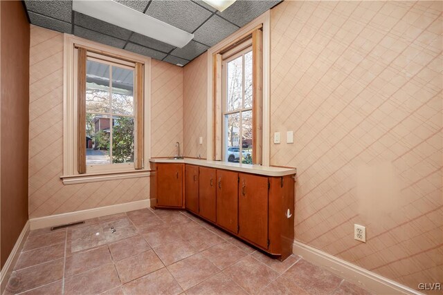 bathroom featuring tile patterned flooring and a drop ceiling