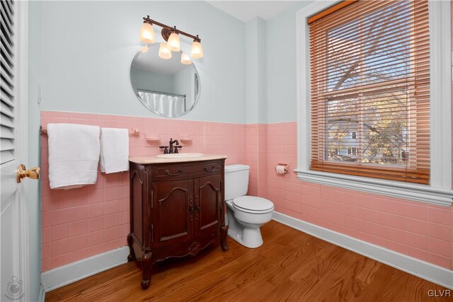 bathroom featuring hardwood / wood-style floors, vanity, toilet, and tile walls