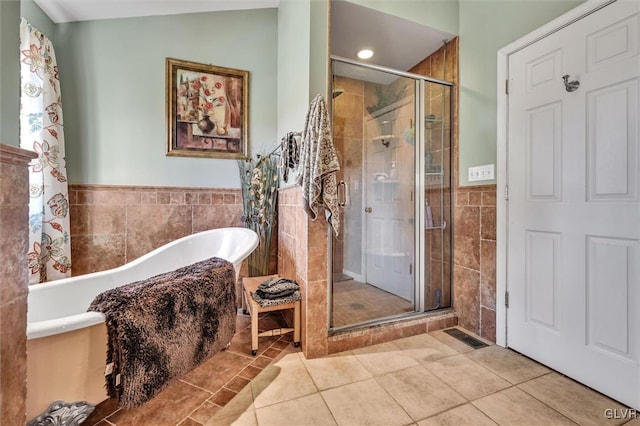 bathroom with lofted ceiling, tile patterned floors, separate shower and tub, and tile walls