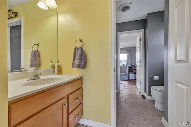 bathroom with toilet, vanity, and tile patterned flooring