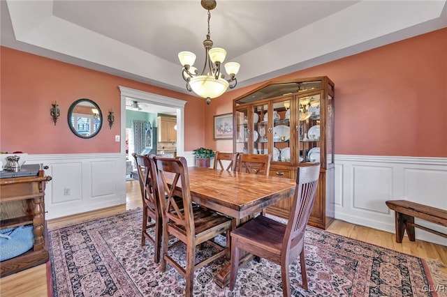 dining area with light wood-type flooring and a notable chandelier