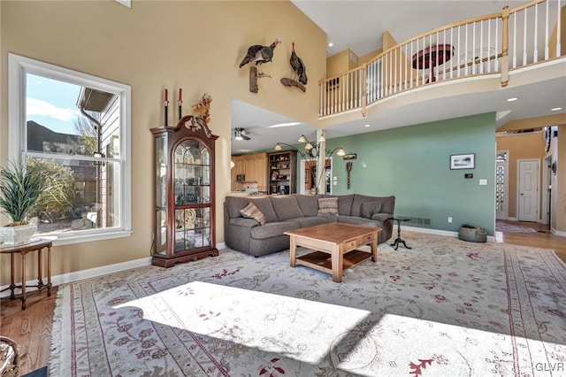 living room featuring a high ceiling and light hardwood / wood-style flooring