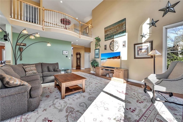 living room with a high ceiling and light hardwood / wood-style flooring