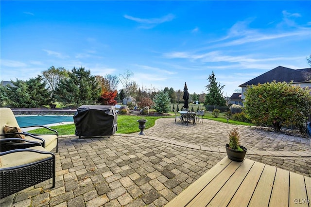 view of patio with area for grilling and a covered pool