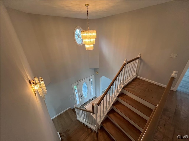 stairs featuring a chandelier and wood-type flooring