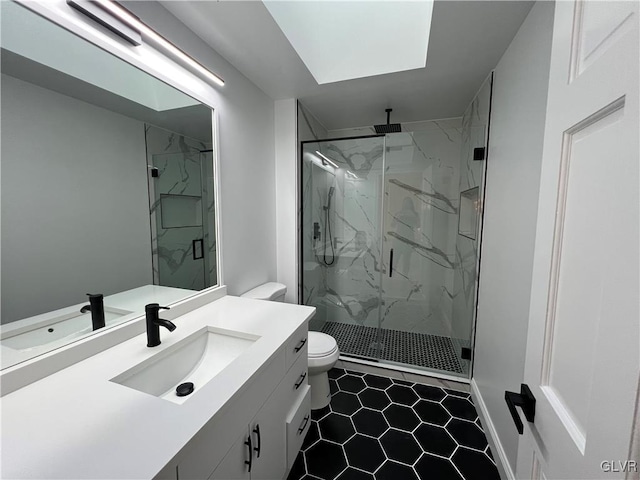 bathroom with vanity, tile patterned flooring, toilet, a skylight, and a shower with shower door