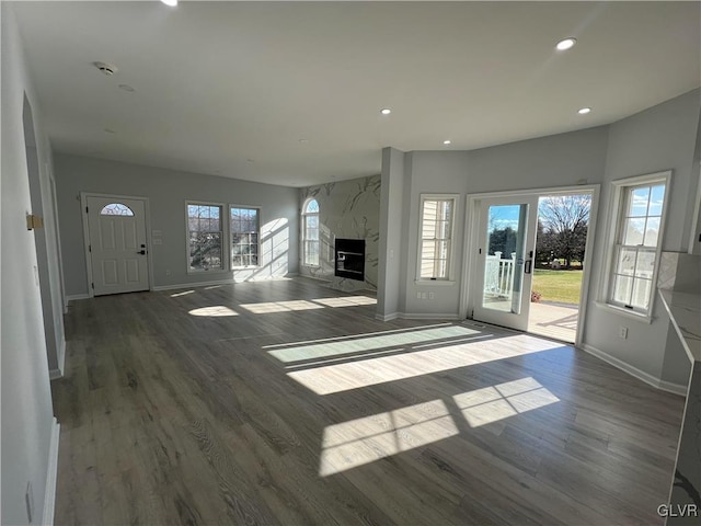 unfurnished living room featuring dark hardwood / wood-style flooring and a premium fireplace