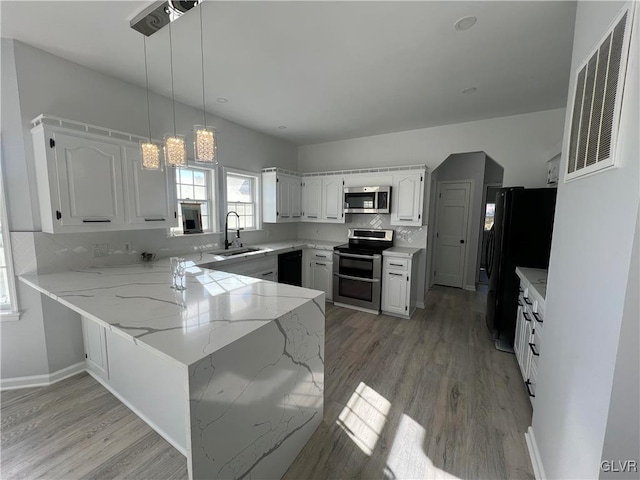 kitchen featuring black appliances, white cabinetry, pendant lighting, sink, and kitchen peninsula