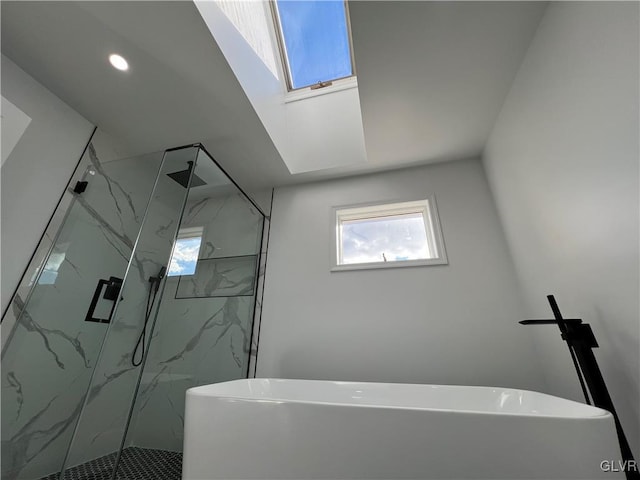 bathroom featuring a skylight and independent shower and bath