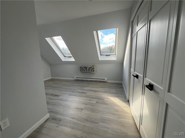 bonus room featuring a baseboard radiator, light wood-type flooring, and lofted ceiling with skylight