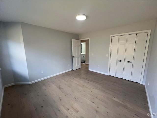 unfurnished bedroom with a closet and hardwood / wood-style floors