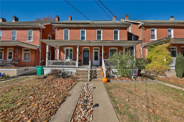 townhome / multi-family property featuring covered porch