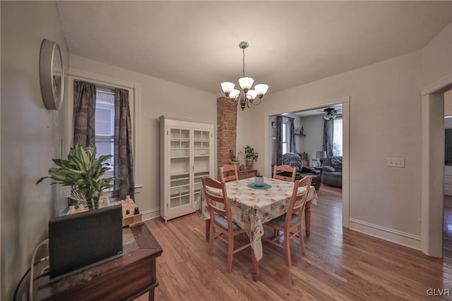 dining space featuring hardwood / wood-style floors and ceiling fan with notable chandelier