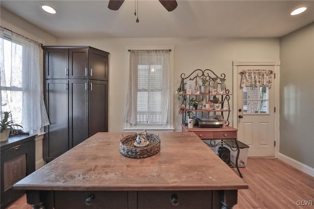 kitchen with a kitchen island, light wood-type flooring, dark brown cabinets, and ceiling fan