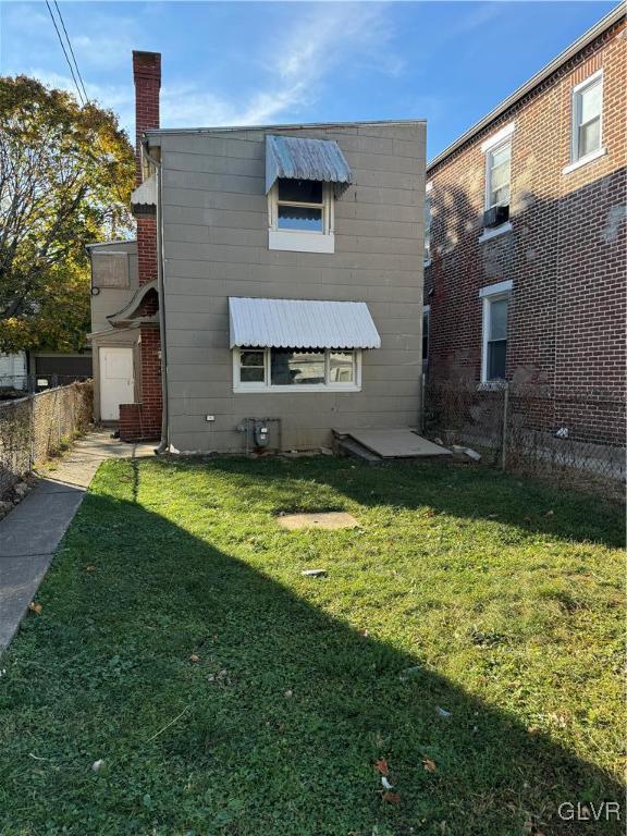 back of house featuring a yard