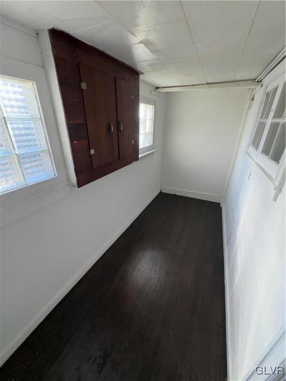 unfurnished room with dark wood-type flooring and a wealth of natural light