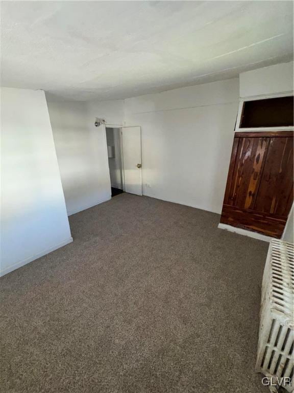 carpeted empty room with radiator