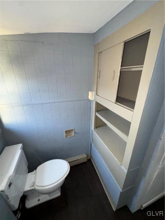 bathroom featuring tile walls and toilet